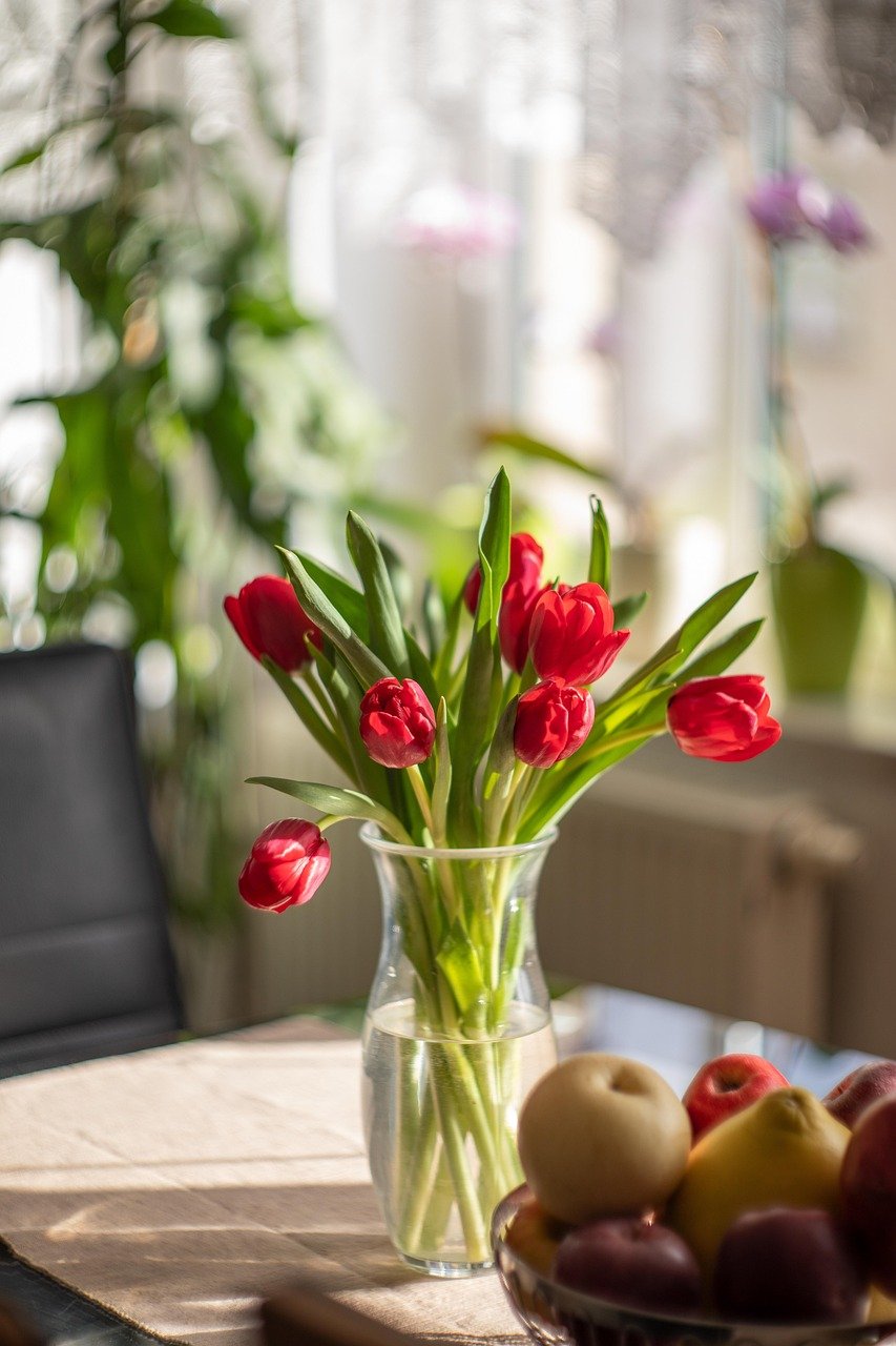 Budget-Friendly Home Staging Tips red tulips and bowl of fruit close up photo